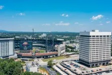 Thumbnail for Aerial view of Truist Park baseball stadium with surrounding buildings and parking lots under blue sky.