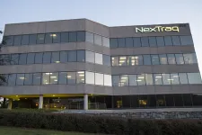 Thumbnail for NexTraq office building at dusk with lights on inside and clear exterior windows.