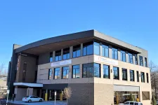 Thumbnail for Modern three-story office building with large windows and clear blue sky background