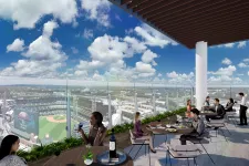 Thumbnail for People dining on a rooftop terrace overlooking a baseball stadium and city under a blue sky with clouds.