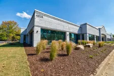 Thumbnail for Modern single-story office building with large windows, landscaped garden, and clear blue sky at 4025 address.