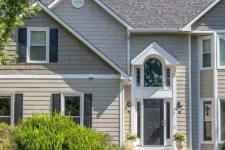 Thumbnail for Front view of a modern two-story gray house with black shutters, white trim, and green landscaping in daylight