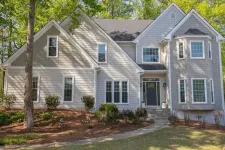 Thumbnail for Two-story modern gray house with large windows surrounded by trees and landscaped garden under sunlight