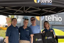 Thumbnail for Four smiling staff at a Telhio Credit Union booth with branded tent and giveaways outdoors
