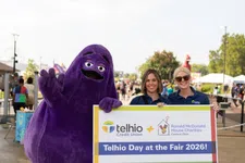 Thumbnail for Two women and a purple mascot hold a sign for Telhio Day at the Fair 2026 supporting Ronald McDonald House Charities.