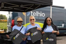Thumbnail for Three women in Telhio Credit Union shirts holding branded drawstring bags under a Telhio tent with a Telhio van in background