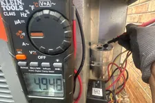Thumbnail for AC Repairs in Tucker Atlanta by The Air Company of GA. HVAC technician using a Klein Tools digital clamp meter to measure electrical current on an outdoor condenser unit.