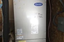 Thumbnail for Atlanta Doraville AC Repair by The Air Company of GA.  Carrier HVAC unit installed in an insulation-lined utility space with pipes and wiring visible.