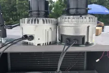 Thumbnail for Two HVAC blower motors side by side on a metal surface with tools and screws nearby outdoors.