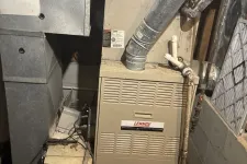 Thumbnail for Lennox furnace and ductwork installed in a basement utility area with visible pipes and insulation.