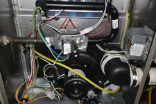 Thumbnail for AC Cooling Repair in Atlanta 30318 by The Air Company. Interior view of a gas furnace showing wiring, burner assembly, blower motor, and gas valve components.
