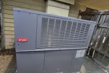 Thumbnail for Bryant outdoor HVAC unit installed on concrete blocks next to a wooden fence and house exterior.