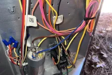 Thumbnail for Atlanta AC Cooling Air Conditioner Repair in Vinnings 30339 by The Air Company of GA. Close-up of an HVAC unit's wiring and components including a capacitor and colored electrical cables inside metal casing.