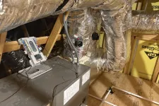 Thumbnail for Attic HVAC system with insulated ductwork, control panel, and wooden framing in a residential home.