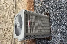 Thumbnail for Outdoor Lennox air conditioning unit installed beside brick wall and gravel ground.