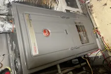 Thumbnail for Gray Rheem Prestige Series gas furnace installed in a basement with insulating foil and visible pipes.