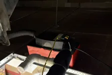 Thumbnail for Ceiling area with insulated black pipe, white PVC pipe, red tool box, and electrical wires in dim light.