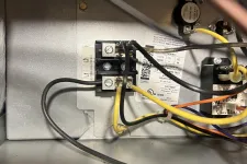 Thumbnail for Marietta AC Cooling Air Conditioner Repair in 30067 by The Air Company of GA. Close-up of electrical wiring and components inside a metal panel, showing black, yellow, and orange wires.
