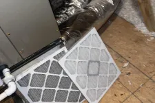 Thumbnail for Atlanta AC Cooling Air Conditioner Repair in Vinnings 30339 by The Air Company of GA.  Two HVAC air filters, one clean and one dirty, placed near an air duct in an attic space with insulation visible.