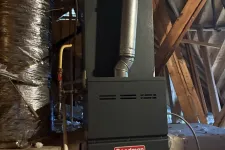 Thumbnail for Goodman furnace installed in attic with insulated ductwork and exposed wooden beams around.