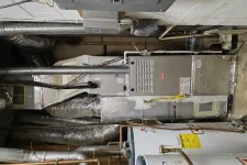 Thumbnail for Furnace and water heater system with insulated ducts and exposed piping in a basement utility room.