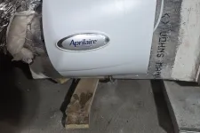 Thumbnail for AC Cooling Repair in Atlanta 30306 by The Air Company of GA.  Aprilaire humidifier unit installed on ductwork with insulation and pipes in basement area.