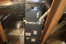 Thumbnail for HVAC system installed in a wooden attic with insulated ductwork and wiring around the unit.