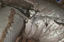 Thumbnail for AC Cooling Repair in Sandy Springs 30328 by The Air Company of GA. Torn and damaged silver insulated HVAC ductwork with exposed insulation in attic space showing repair need.