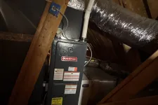 Thumbnail for Goodman furnace unit installed in a dark attic with wooden beams and insulated ducts.