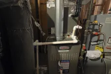Thumbnail for Residential AC Cooling Repair in Atlanta 30327 by The Air Company of GA.  Lennox furnace and water heater setup in a home's utility area with pipes and insulation visible.
