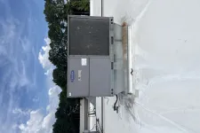 Thumbnail for Commercial rooftop HVAC unit on white roof under blue sky with scattered clouds and trees in background.