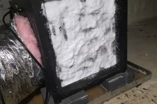 Thumbnail for Air purifier filter covered in white foam during cleaning in an indoor setting with ductwork and floor visible.