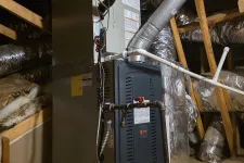 Thumbnail for Modern HVAC furnace unit installed in attic with insulated ducts and wooden framing visible