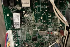 Thumbnail for AC Repair in Roswell GA by The Air Company of GA. Close-up of a complex electronic circuit board with multicolored wires connected inside a device.