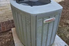 Thumbnail for Residential AC Cooling Repairs in Sandy Springs 30350 by The Air Company of GA. Outdoor Lennox Elite air conditioning unit on concrete pad next to brick house with cordless drill on top