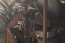 Thumbnail for Residential AC Cooling Repairs in Sandy Springs 30350 by The Air Company of GA. Close-up of old metal pipes and valves wrapped with torn foil insulation in a basement storage area.