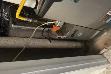 Thumbnail for Basement furnace with yellow gas line, insulated ducts, and rusted pipe in a utility space near tiled floor.