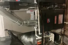 Thumbnail for Indoor Goodman furnace and duct system with metal pipes and ventilation components in a utility room.