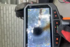 Thumbnail for Inspection camera screen displaying the interior of a pipe with rust and debris.