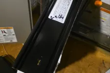 Thumbnail for AC Cooling Air Conditioner Repair in Atlanta 30319 Brookhaven by The Air Company of GA.  Close-up of HVAC air filter installation with focus on black filter frame and furnace pipes in basement.