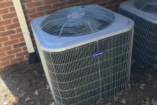 Thumbnail for Atlanta AC Cooling Air Conditioner Repair in Vinnings 30339 by The Air Company of GA. Two Carrier outdoor air conditioning units next to a brick wall with dried leaves and pine straw on the ground.