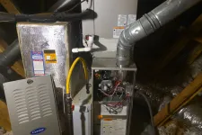 Thumbnail for AC Air Conditioning Repair in Roswell 30075 by The Air Company of GA.  Furnace with exposed wiring and metal ducts installed in an attic with insulation and wooden beams.