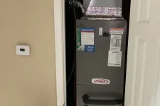 Thumbnail for Sandy Springs Atlanta AC Repair by The Air Company of GA.  Indoor HVAC system unit with thermostat on beige wall and black speaker in room with carpet.