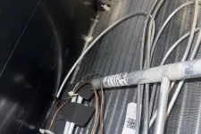 Thumbnail for Marietta AC Cooling Air Conditioner Repair in 30067 by The Air Company of GA. Close-up of HVAC coil with metal pipes, copper tubing, and insulated wiring inside an air conditioning unit.