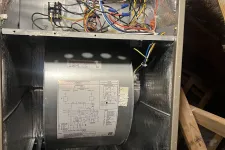 Thumbnail for Marietta AC Cooling Air Conditioner Repair in 30067 by The Air Company of GA. Inside view of an HVAC furnace showing wiring, a blower motor with a wiring diagram, and metal insulation panels.