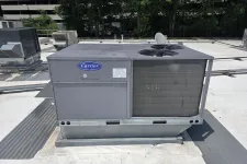 Thumbnail for Carrier rooftop HVAC unit installed on a commercial building with trees and other units visible.