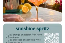 Thumbnail for Sunset-lit orange spritz cocktail in a glass with a metal shaker and sliced orange on a table outdoors.