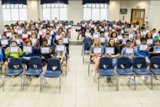 Thumbnail for a group of people sitting in chairs with laptops in their hands