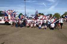 Thumbnail for a group of people holding flags with Cadillac Ranch in the background