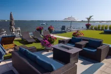 Thumbnail for a patio with chairs and tables and umbrellas overlooking a body of water